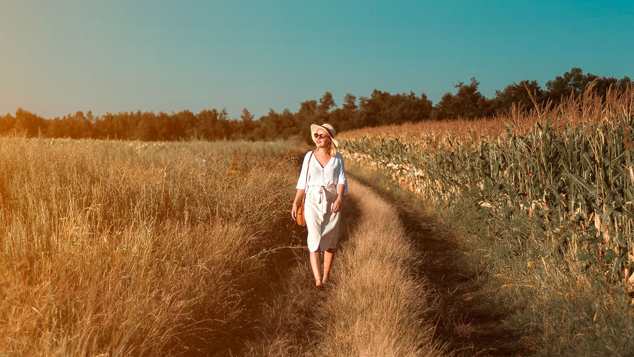 Retiree woman walking on the rice field