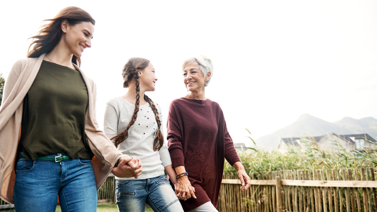 Three women walking happily and holding hands